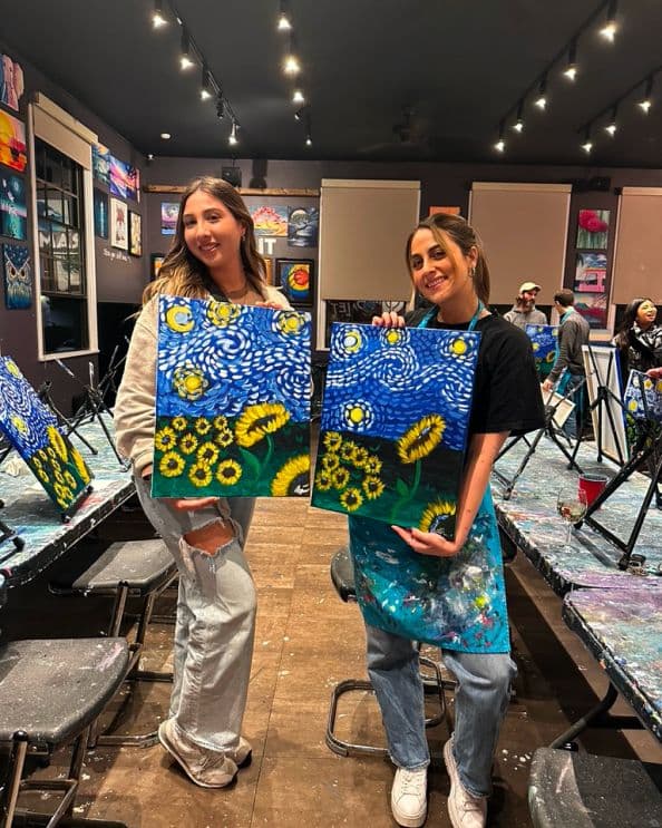 Team showing off canvases at the paint and sip event